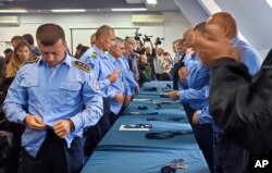 Aleksandar Filipoviq, i pari në anën e majtë të fotografisë, shihet duke hequr uniformën e Policisë së Kosovës.