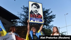 Sudija Volf smatra da Putin neće putovati u Pretoriju kako je planirao. Skup podrške Ukrajini sa likom predsednika Rusije Vladimira Putina, za vreme posete Južnoafričkoj Republici ruskog ministra spoljnih poslova Sergeja Lavrova. Pretorija, 23. januar 2023.