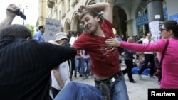 A gay rights activist clashes with an Orthodox Christian activist in Tbilisi on May 17, 2012.
