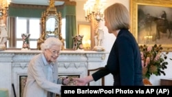 Regina Elisabeta a II-a a Marii Britanii, stânga, îi urează bun venit lui Liz Truss în timpul unei audiențe la Balmoral, în Scoția, unde a invitat-o pe noua șefă aleasă a Partidului Conservator să devină prim-ministru și să formeze un nou guvern, marți, 6 septembrie 2022.