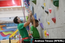 Răzvan Nedu, căpitanul Lotului Național de Paraclimbing, îi indică mișcările pe traseu sportivului nevăzător Angelo Simionescu, în timpul antrenamentului de la Centrul Climb Again din București.