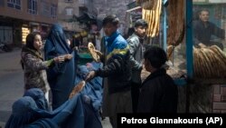 زنان و کودکان فقیر در مقابل یک نانوایی در کابل 