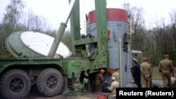 Робітники вилучають боєголовку радянської ядерної ракети SS-19 із шахти на військовій базі біля українського міста Хмельницький, готуючи її до відправки до Росії, квітень 1995 року