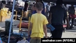 Bazarda işleýän çaga. Iýul, 2024. Türkmenistanda köp çaga tomusky dynç alyş möwsümini agyr işde işläp geçirýär. 