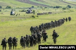 Іспанські, німецькі та нідерландські солдати біля військових гелікоптерів німецької, іспанської та румунської армій на полігоні Богата, Румунія, 14 травня 2024 року в рамках військових навчань Swift Response 24