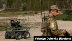 Ukrajinski vojnik upravlja kopnenim dronom na neotkrivenoj lokaciji u Ukrajini, aprila 2024.