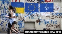 Графити на ѕидот во стариот град Тбилиси ги прикажуваат знамињата на Украина, ЕУ и НАТО 