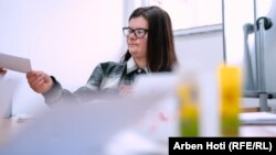 Ndalore Likaj i dorëzon punëtores sociale kartolinën e punuar në shoqatën Down Syndrome Kosova në Prizren, më 16 janar 2024.