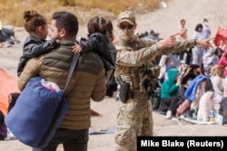 О​фицер пограничного патруля США направляет мигранта. Калифорния, 11 мая 2023 года