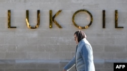 A woman walks past the headquarters of Russia's oil producer LUKoil in Moscow. (file photo)