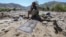 A man affected by floods sits next to a prayer mat as he waits for relief in the village of Borka in Baghlan Province in May.