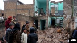 د مارچ پر ۱۲مه په هرات کې ماشومان په باران کې له خپل نړېدلي کور سره ولاړ دي.