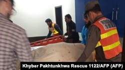 په باجوړ کې د مرستندویه ادارې کارکوونکي د وژل شویو سرتېرو مړي روغتون ته انتقالوي - د جنورۍ اتمې انځور.