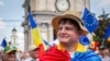 Un tânăr cu steagul Republicii Moldova pe umeri și cel al Uniunii Europene la pălărie participă la un miting pro-UE în Chișinău, pe 21 mai 2023.