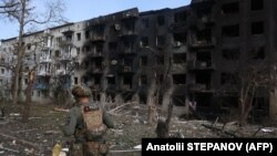 Un ofițer de poliție ucrainean lângă o clădire rezidențială distrusă în urma raidurilor aeriene rusești în satul Ocheretyne, lângă orașul Avdiivka, în regiunea Donețk, 15 aprilie 2024.