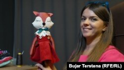 Doruntina Ukimeri duke mbajtur në duar një kukull të punuar nga ajo.