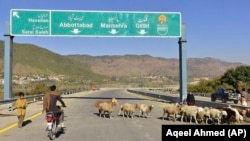 Motociklist vozi pored ovaca na novoizgrađenoj cesti u Haripuru, Pakistan, 22. decembra 2017. Pakistan je jedna od zemalja čiji je dug najviši prema Kini. 