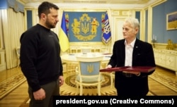 Ukrayına prezidenti Volodımır Zelenskıy qırımtatar halqınıñ milliy lideri, halq deputatı Mustafa Cemilevge (sağdan) Ukrayına Qaramanı unvanını berdi. Kyiv, 2023 senesi noyabrniñ 13-ü