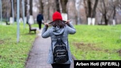 Ndalore Likaj duke rregulluar flokët poshtë kapelës së kuqe, pasi përfundoi orarin e punës.