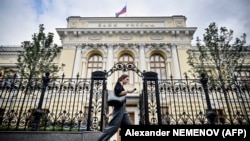 Një grua ec pranë selisë së Bankës Qendrore të Rusisë në Moskë.