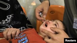 په پېښور کې یو روغتیايي کارکوونکی ماشوم ته د ګوزڼ مخنیوي څاڅکي ورکوي - انځور له ارشيفه.