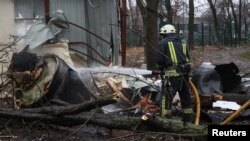 A firefighter extinguishes the remains of an unidentified missile that Kyiv claims was made in North Korea at the site of a Russian strike in Kharkiv on January 2.
