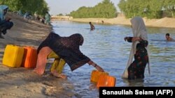 یک دختر باشنده حومه شهر قندهار بشکه هایش را از آب دریا پر می کند. July 16, 2023