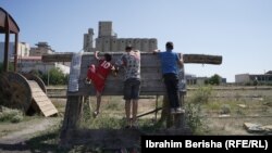 Disa fëmijët duke u ngjitur në një mur nga druri.