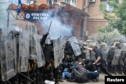 Protestuesit serbë duke goditur pjesëtarë të misionit të NATO-s në Kosovë, KFOR, me shkopinj, në hyrje të ndërtesës komunale në Zveçan, komunë në veri e banuar me shumicë serbe. (Foto: Reuters)