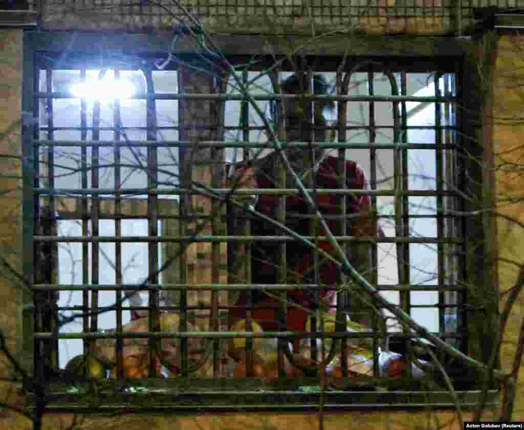 Navalnîi se uită pe fereastra celulei sale din Moscova, în decembrie 2011. El a fost condamnat la 15 zile de detenție pentru &bdquo;împotrivire față de forțele de ordine&rdquo;. A fost prima detenție din ceea ce avea să devină ulterior evenimente obișnuite.