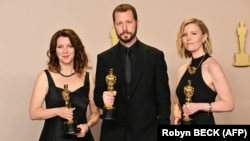 Український режисер Мстислав Чернов (посередині), Рені Аронсон-Рат і Мішель Мізнер (праворуч) позують з премією «Оскар» за найкращий документальний фільм – кінострічку «20 днів у Маріуполі». Голлівуд, 10 березня 2024 року