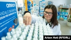 Ndalore Likaj duke sistemuar produktet në barnatoren ku ajo punon.