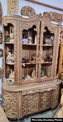 Një vitrinë druri e gëdhendur me motive floreale në të cilën autori Pirro Icka ka punuar 3 vjet.