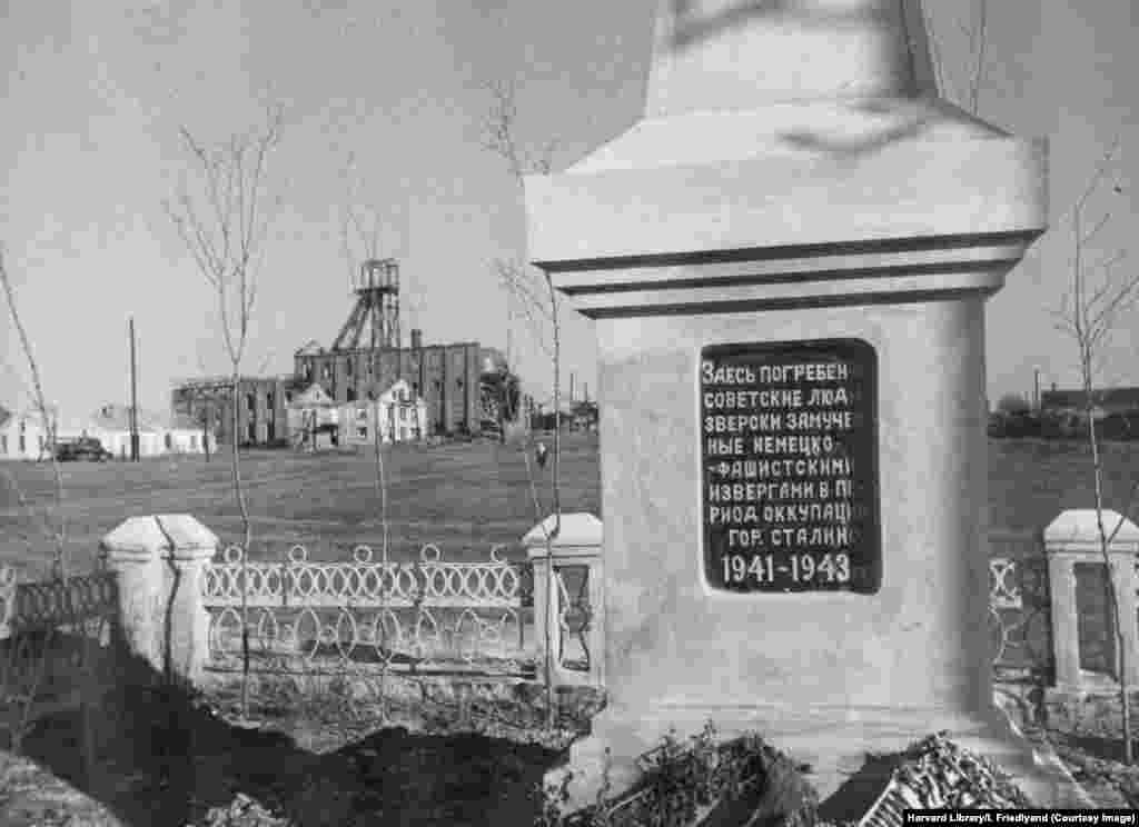 Memorial lângă un puț neidentificat. Pe inscripție scrie: &bdquo;aici zac sovietici torturați până la moarte de germanii fasciști în timpul ocupației Stalino, 1941-1943&rdquo;. Milioane de ucraineni au fost uciși în Al Doilea Război Mondial de forțele de ocupație naziste. Ocupația a urmat la scurt timp după decimarea populației ucrainene de către Uniunea Sovietică, prin foametea decisă de Kremlin, numită Holodomor.&nbsp;