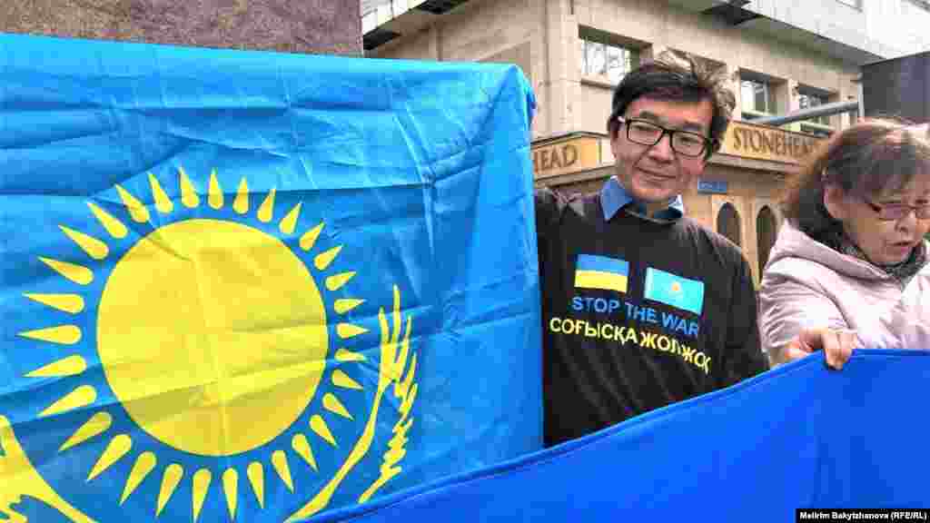 Бейбіт акцияға қатысқан құқық қорғаушы Ғалым Ағелеуов: "Зұлымдық жазасыз қалмауы керек. Өз халқын зомбиге айналдырған Путинді Гаага сотында заңға сәйкес жауапқа тарту керек. Әділдікке сай жазаға тартылсын!" деді. Суретте: құқық қорғаушы Ғалым Ағелеуов Қазақстан мен Украинаның мемлекеттік туларын ұстап тұр.