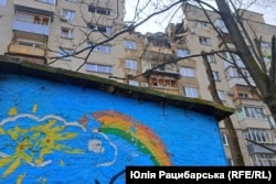 Сонце й веселка, намальовані на майданчику поблизу пошкодженого будинку