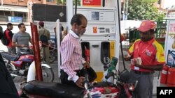 په کراچۍ کې یو کس په موټرسایکل کې تېل اچوي - د اګست لومړۍ نېټې انځور.