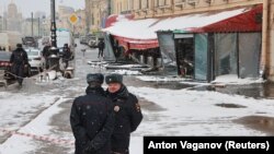 Police officers stand guard at the scene of an explosion in St. Petersburg that killed Russian military blogger Vladlen Tatarsky. 