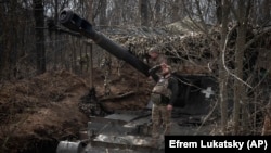 Український військовий дивиться, чи немає в небі російських БПЛА, на позиціях поблизу Бахмута, 25 березня 2024 року