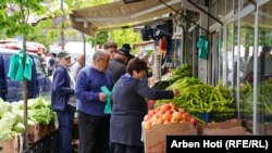 Disa qytetarë duke blerë perime.