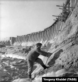 1946: Un muncitor la reconstrucția barajului.