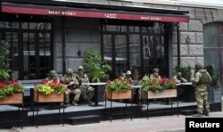 Бойовики приватної групи найманців «Вагнер» відпочивають у кав'ярні під час дислокації на вулиці біля штабу Південного військового округу в місті Ростові-на-Дону, Росія, 24 червня 2023 року