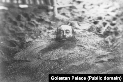 ფოტოზე გამოსახულია, სავარაუდოდ, თბილი ქვიშით მკურნალობის მომენტი. დაავადებების ამგვარ მკურნალობას ფსამოთერაპია ჰქვია და ის პირველად ძველმა ბერძნებმა გამოიყენეს. დღეს ეს მეთოდი არაერთ ქვეყანაშია ცნობილი.