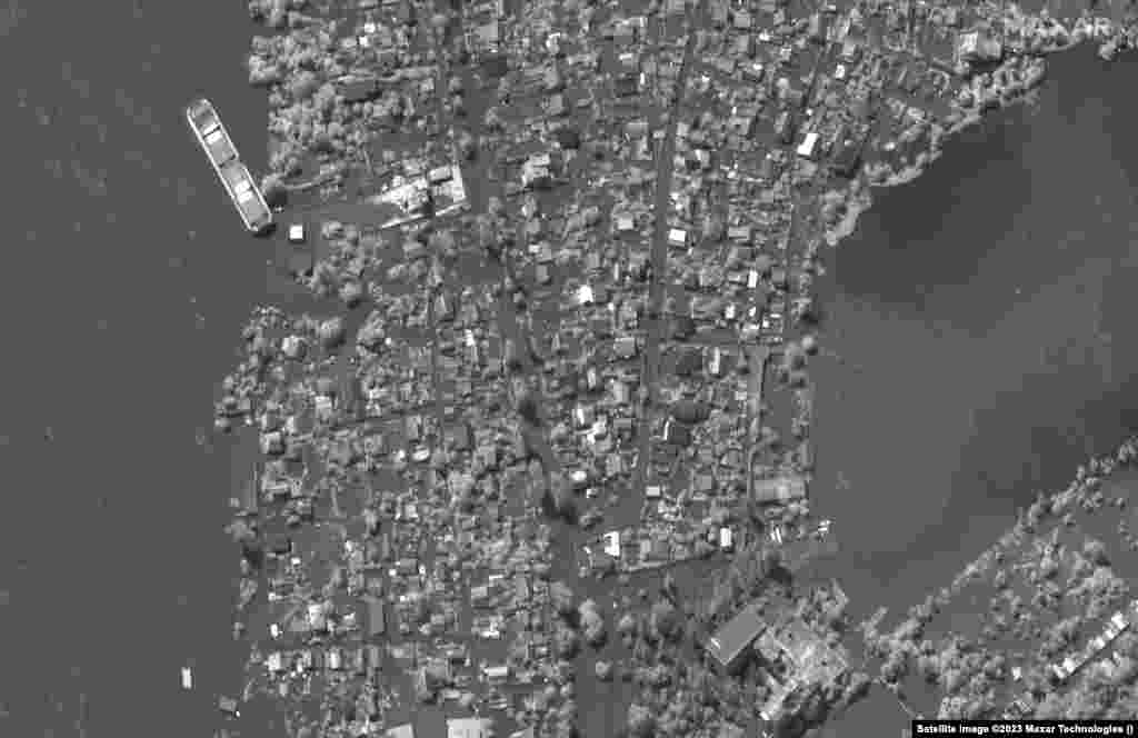 На снимке от 15 мая запечатлены дома вдоль Днепра недалеко от Херсона, рядом &mdash; последствия наводнения 6 июня из-за прорыва Новой Каховской плотины