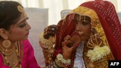 په پاکستان کې یوه ښځه یوه هندوه ناوې سینګاروي - پخوانی انځور.