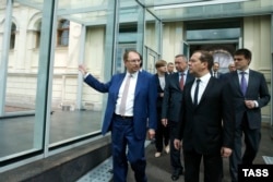 ნიკოლაი კორპაჩოვი, სანკტ-პეტერბურგის უნივერსიტეტის რექტორი (მარცხენა, აწეული ხელით) და დმიტრი მედვედევი, რუსეთის ყოფილი პრეზიდენტი