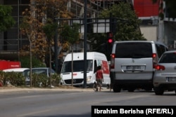 Një djalë i ri duke lypur para në këmbim të pastrimit të xhamave të veturave në rrugët e Prishtinës, Kosovë.