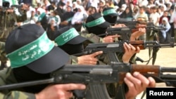 Pripadnici militantne grupe Hamas marširaju sa puškama AK 47 tokom skupa Hamasa u kampu Bureij u Pojasu Gaze 5. marta 2004.