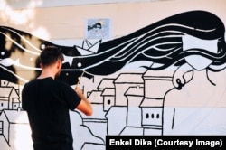 Enkel Dika duke punuar një mural.