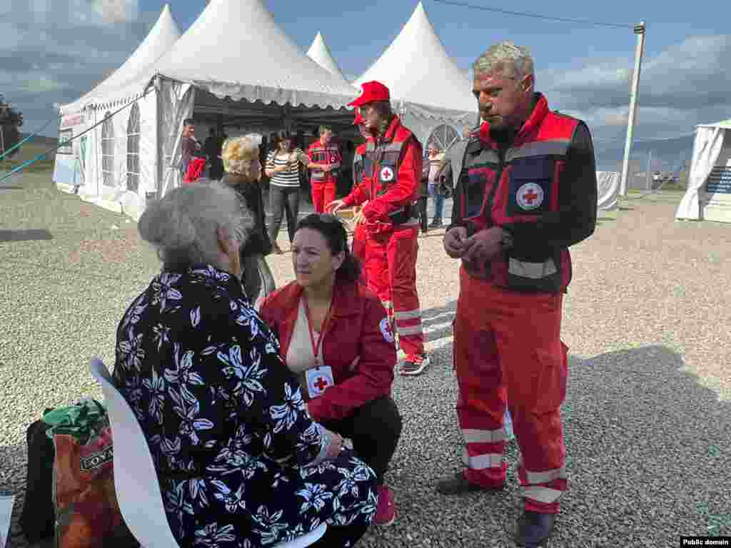 Red Cross workers speak with a refugee in Kornidzor on September 24.&nbsp; Some residents of Nagorno-Karabakh are moving from isolated villages toward Stepenakert amid increasing uncertainty. "We are still moving to Stepanakert," one ethnic Armenian villager told RFE/RL. "Let's see what is decided.&nbsp;It's still uncertain," they said.&nbsp;